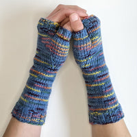Blue striped fingerless gloves held by a person against a white background