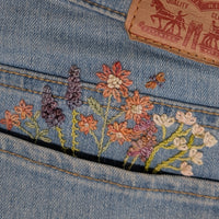 Embroidered floral design on denim fabric with Levi's brand tag.